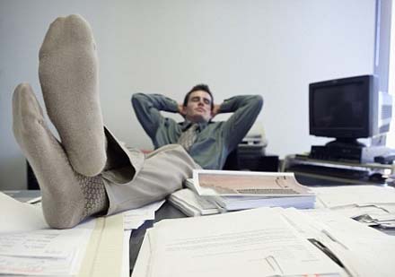 Businessman Relaxing at Desk with Feet Up